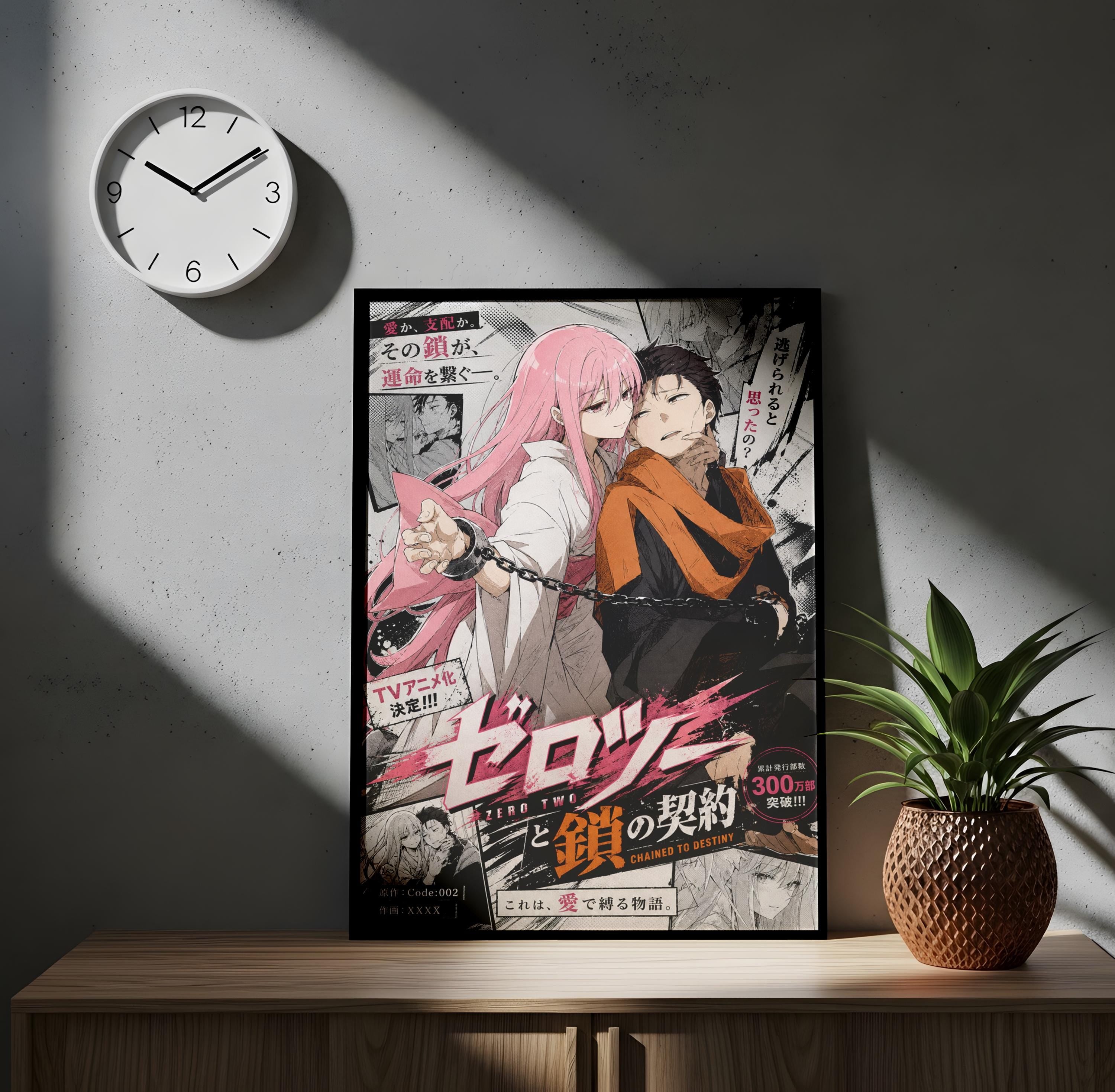 The image is a poster featuring an anime-style illustration of two characters, one with pink hair and the other with dark hair, standing together. The poster is framed and displayed on a wooden surface, with a clock on the wall above it. There is also a potted plant to the right of the poster.